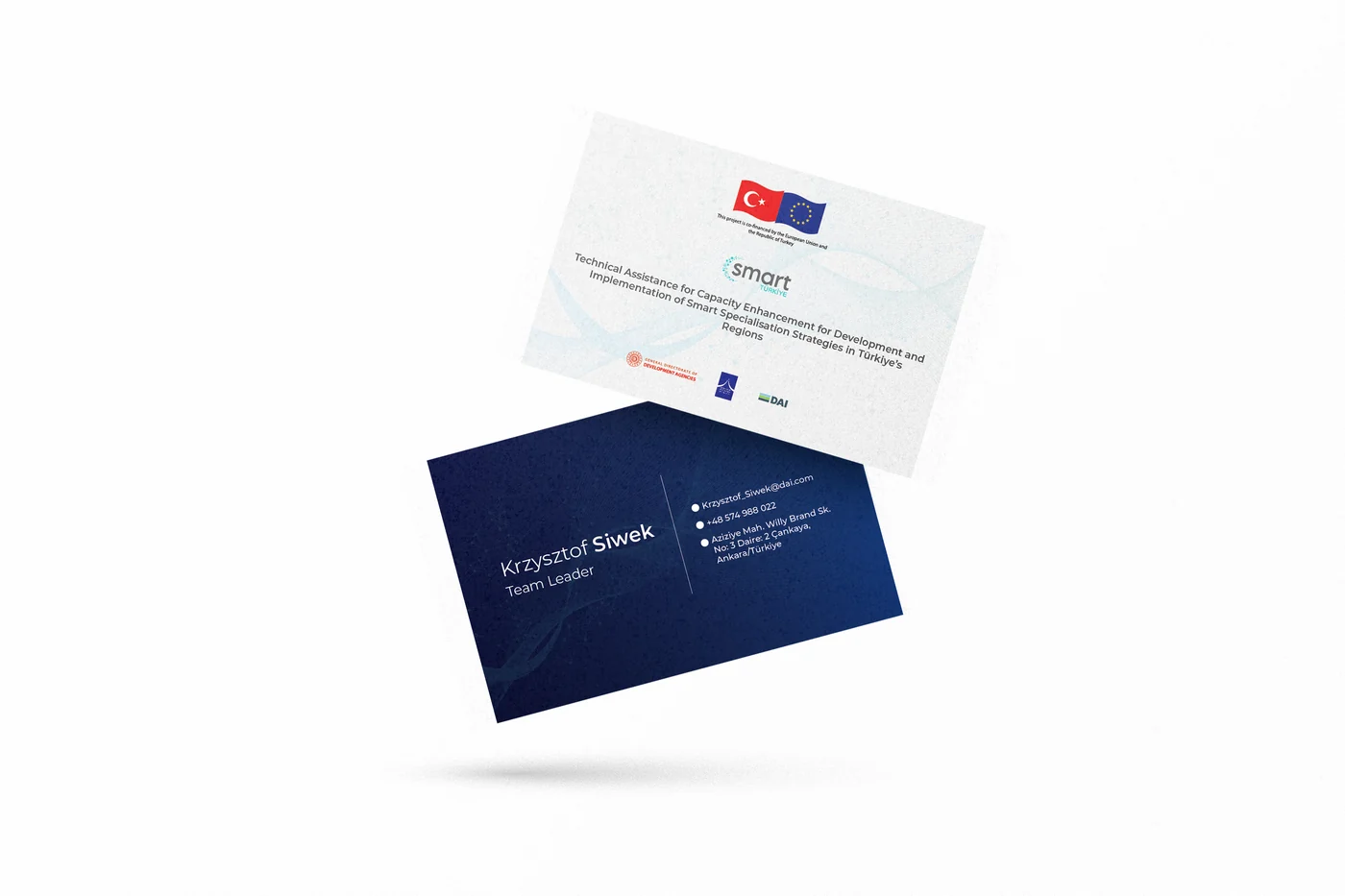 Two navy business cards overlapping on a white surface, one showing the programme mark and one the contact side.