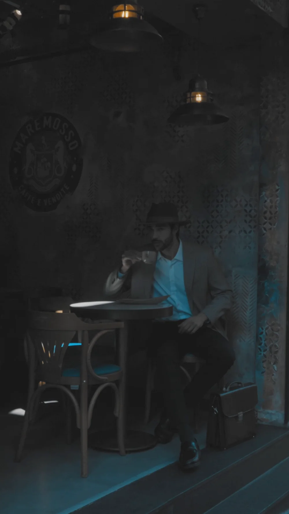 A frame from the men's category film, a dimly lit cafe interior.