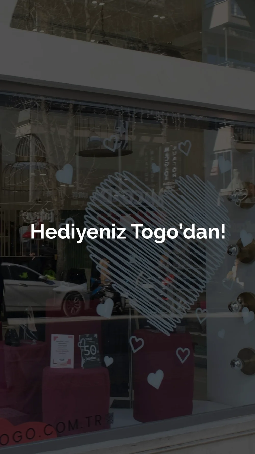 A story shot through a shop window, a drawn heart and a short offer line over it.